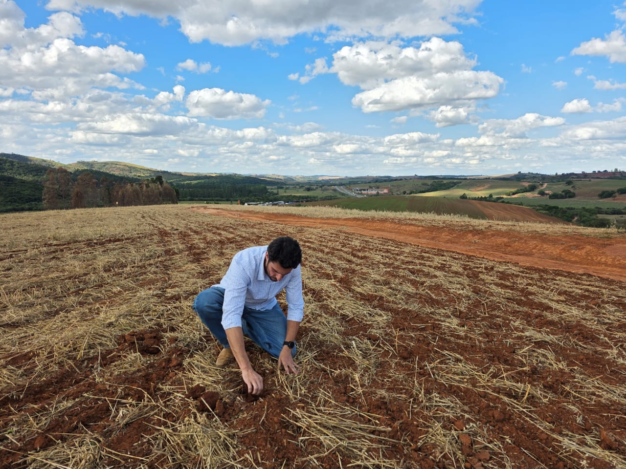 Fábio Kinsch agachado na área de plantio da própria fazenda